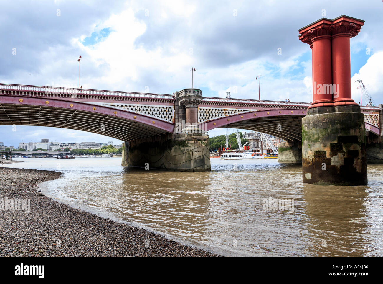 Blackfriars road bridge dalla riva sud del fiume Tamigi a bassa marea, pilastri del ponte vecchio sulla destra, London, Regno Unito Foto Stock