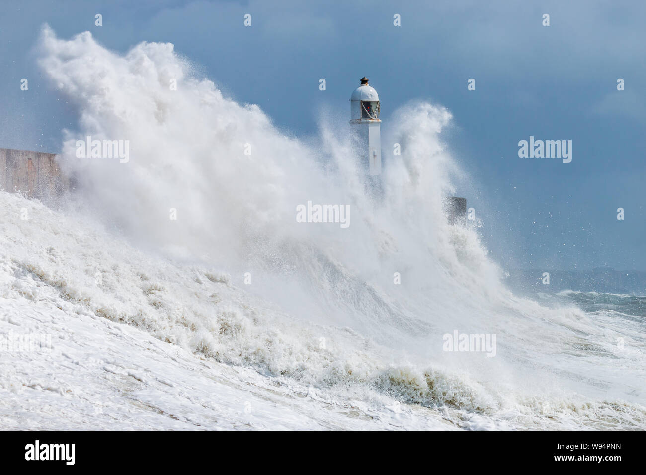 Enorme oceano onde si infrangono in una parete del mare e del faro (Porthcawl, South Wales, Regno Unito) Foto Stock