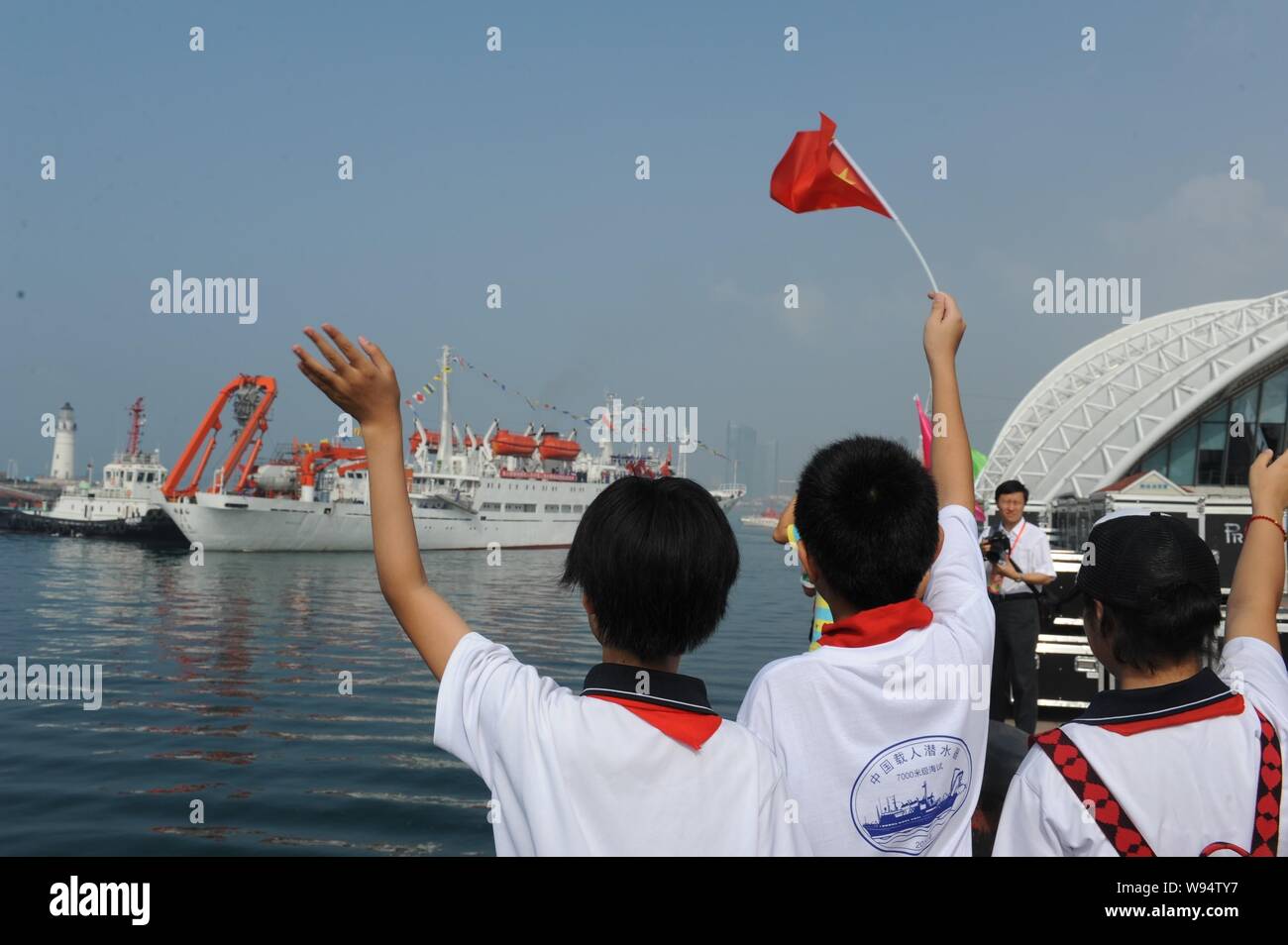 Studenti Cinesi benvenuti la nave oceanografica Xiangyanghong 09 portante Chinese manned deep-sea sommergibili, il Jiaolong, docking al porto di Qingdao, Foto Stock