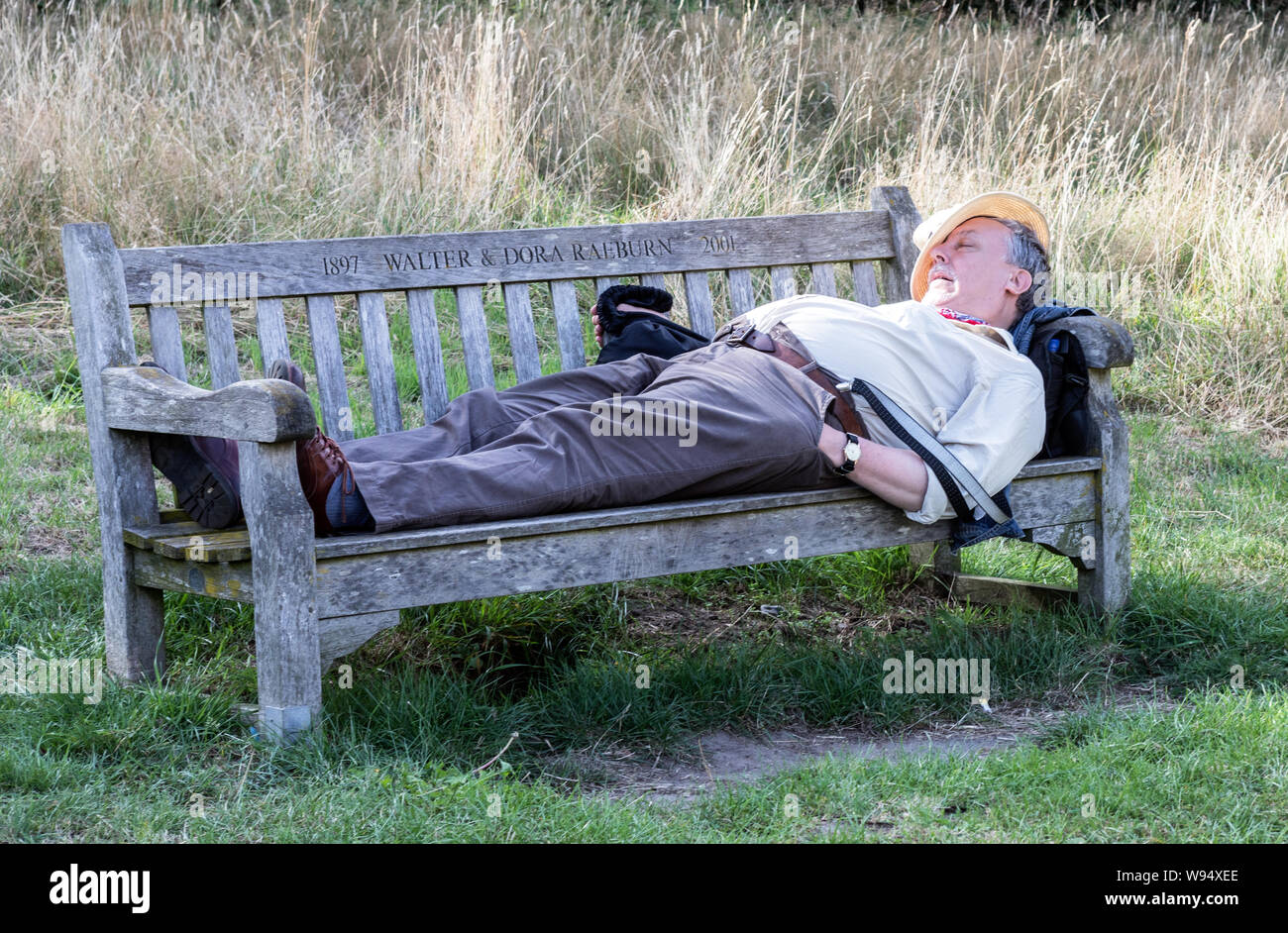 Uomo di dormire su una panchina Kenwood House Hampstead London REGNO UNITO Foto Stock