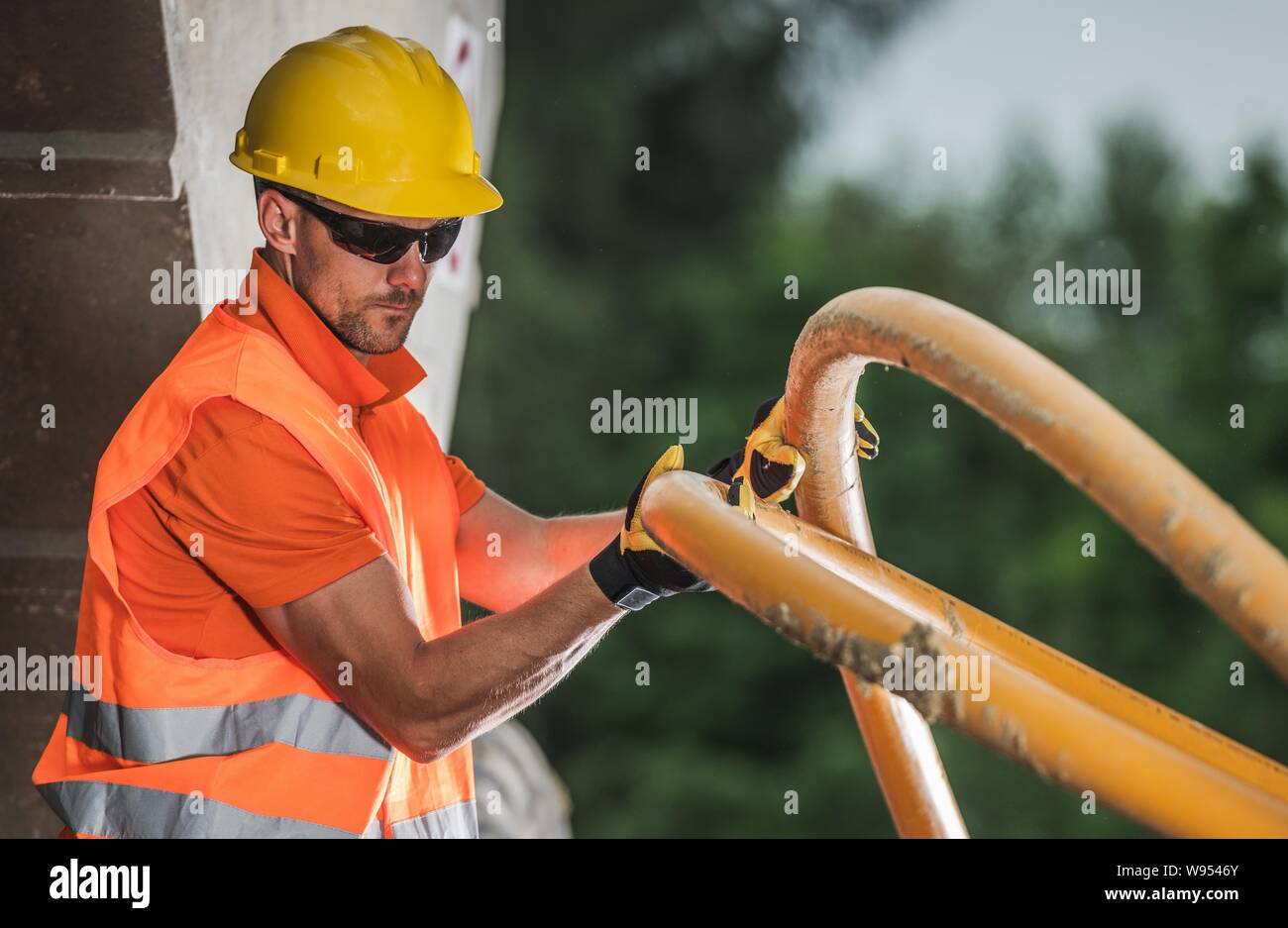 Lavoratore caucasici con alta tensione tubo di plastica. Metropolitana linea elettrica dell'installazione. Industria edile. Foto Stock