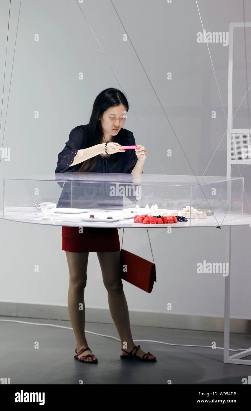Un visitatore prende le immagini dei pezzi di arte durante il nuovo design italiano 2.0 mostra a Pechino, Cina, 22 luglio 2012. Il grande nuovo contemporaneo Ital Foto Stock