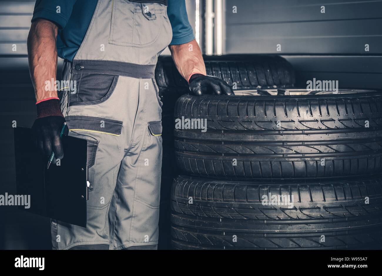 Pneumatici nuovi di ricambio e caucasici Tecnici Automobilistici. Stagionale Cambio di pneumatici. Foto Stock