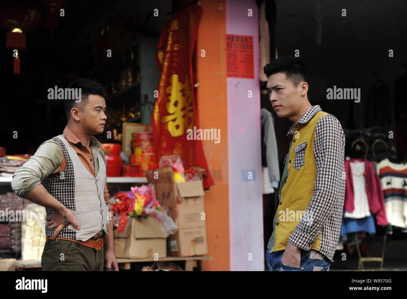 Il cinese coppia gay Lu Zhong, sinistra e Liu Wanqiang, destra, guarda sul davanti di un negozio di vendita di accessori di nozze nella contea Zherong, Ningde città, sou Foto Stock