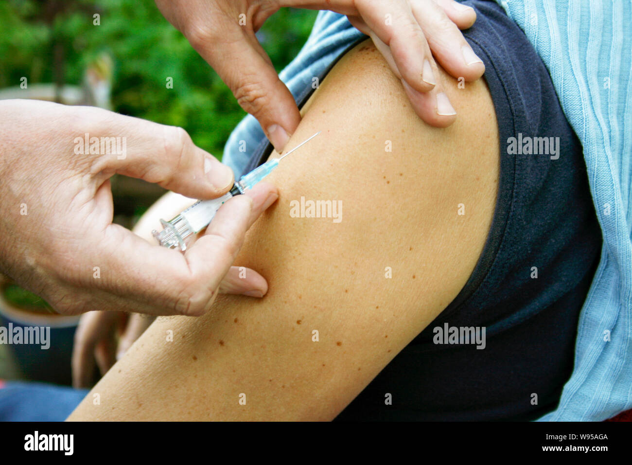 Il medico tiene un ago per iniezione dopo aver somministrato una vaccinazione. Foto Stock