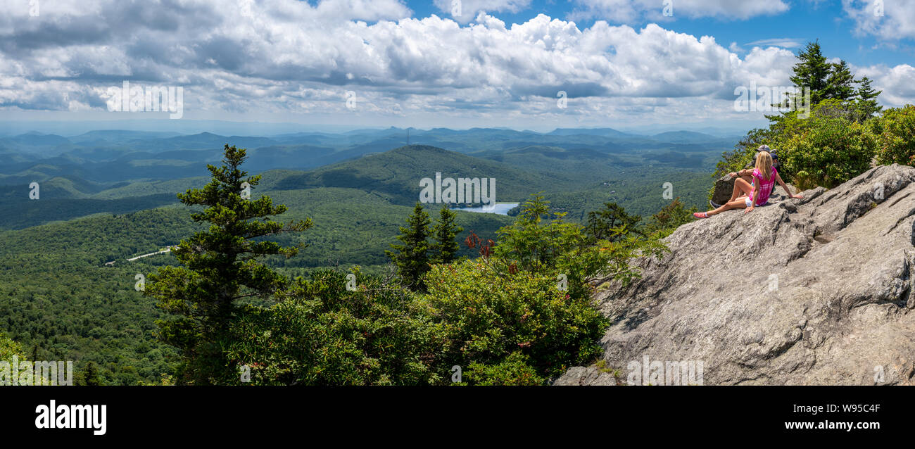 Una donna si rilassa su una sporgenza di roccia vicino alla sommità della montagna del nonno in North Carolina, vicino Boone, Blowing Rock, e la montagna di faggio Foto Stock