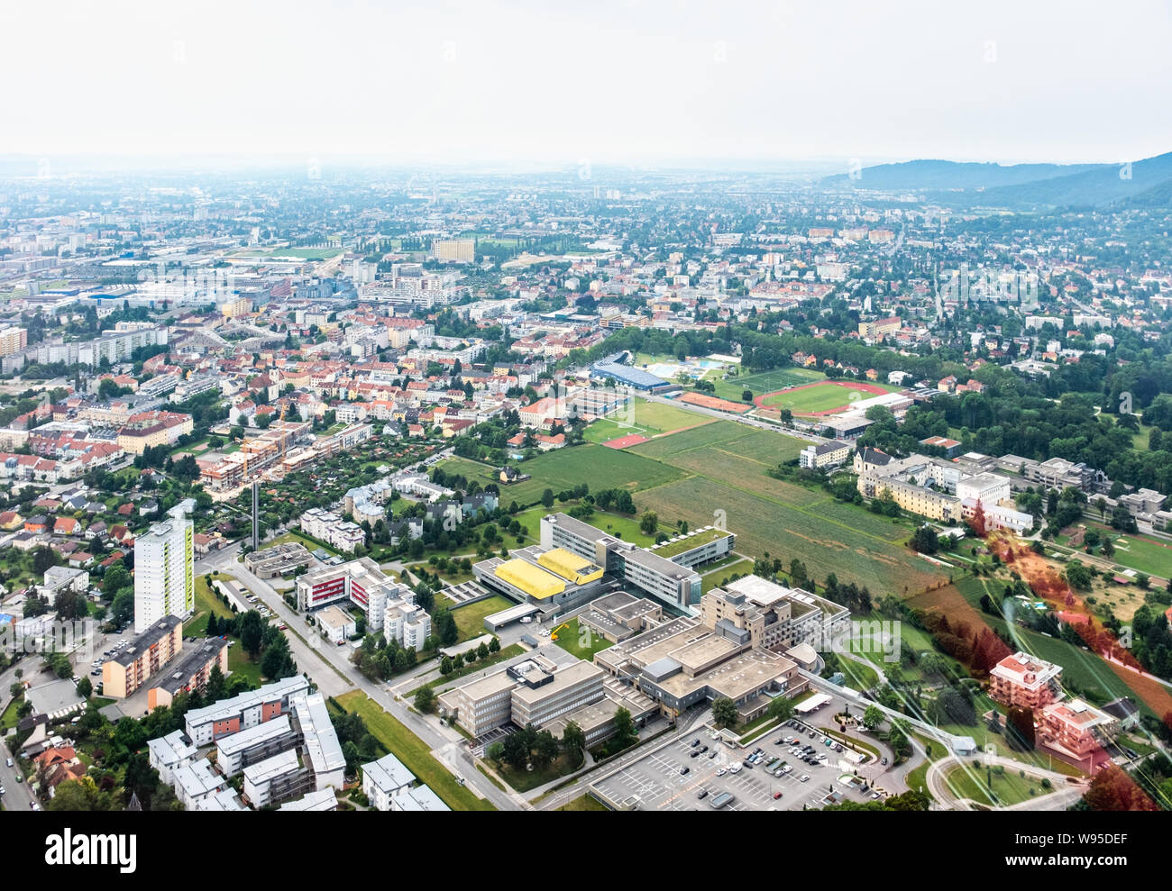 Vista aerea della città di Graz da elicottero drone con i distretti Gösting e l'ospedale ukh su un nuvoloso giorno di estate in Austria, Europa Foto Stock