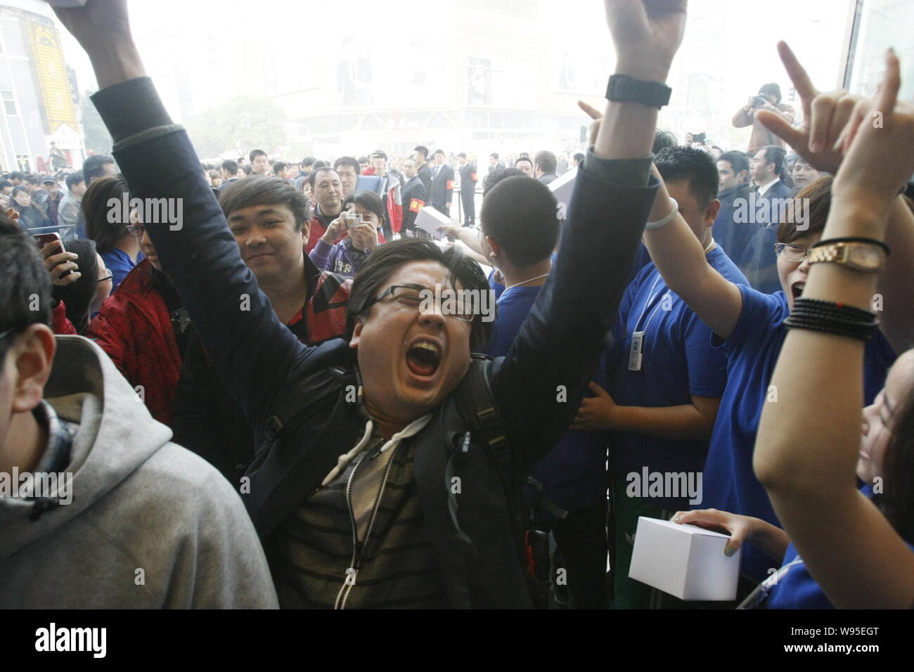 Un uomo celebra tra gli altri come loro di entrare nel negozio Apple Store sulla strada dello shopping di Wangfujing di Pechino, Cina, 20 ottobre 2012. Apple su Saturda Foto Stock