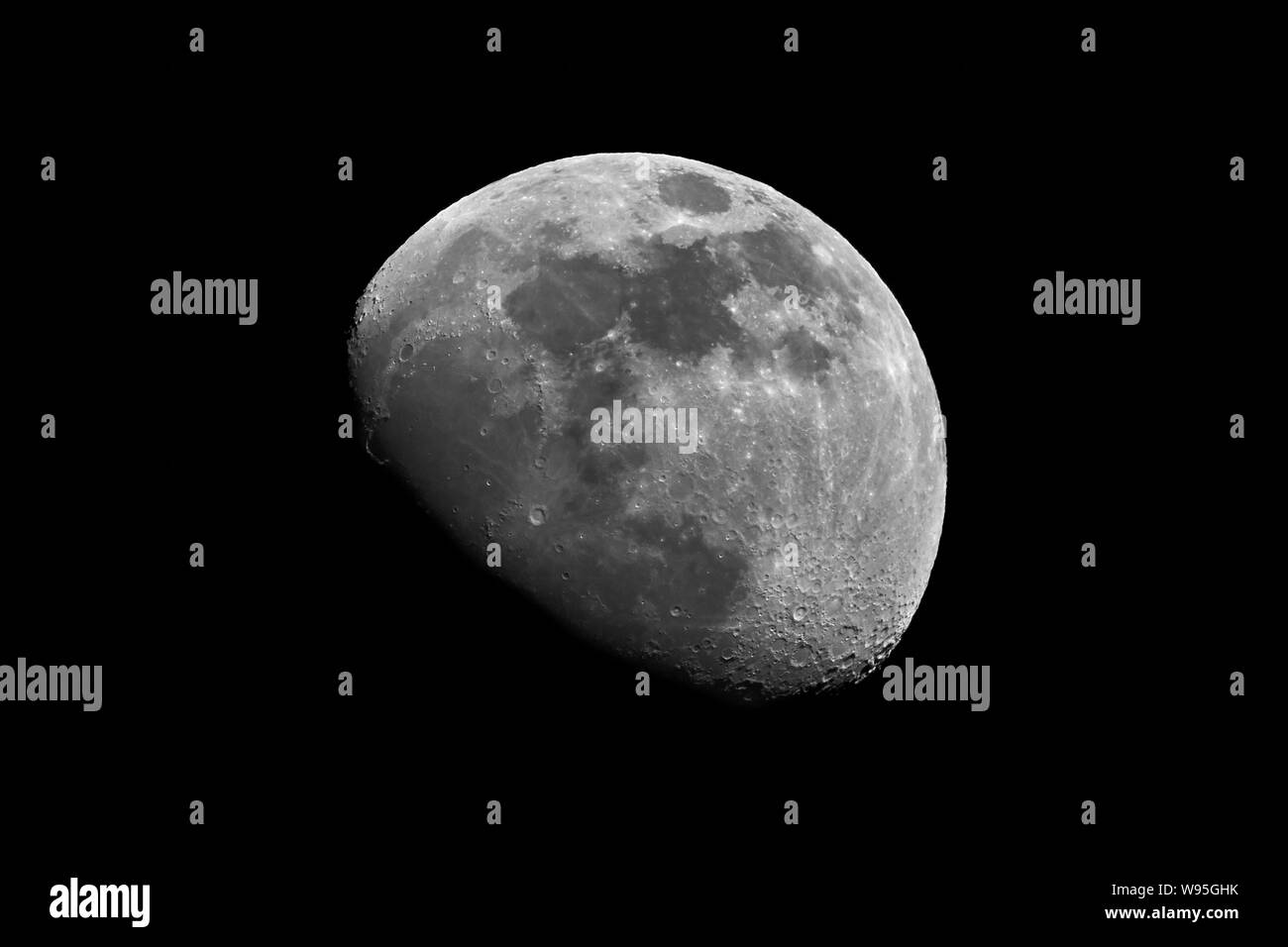 Immagine in bianco e nero della luna in ceretta gibbosa fase in cielo notturno scuro Foto Stock