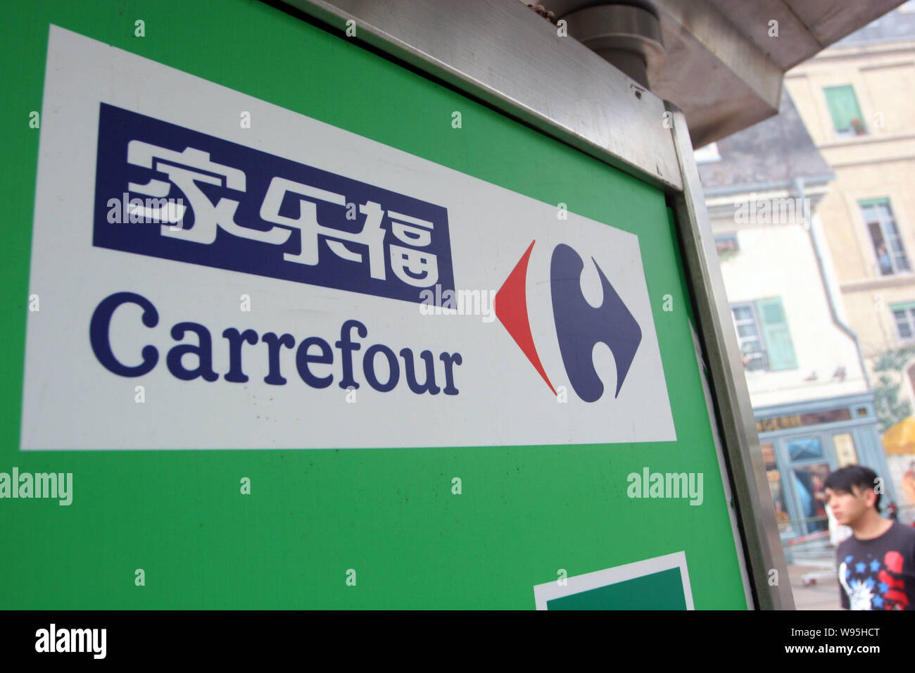 --FILE--A passeggiate a piedi passato un segno bordo di Carrefour in Cina a Shanghai, 30 agosto 2012. Dopo aver tirato fuori dei diversi mercati di tutto il mondo Foto Stock