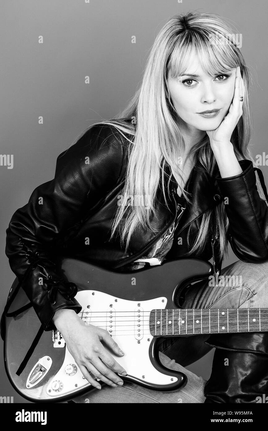 Ritratto di una donna attraente, girato in studio contro uno sfondo grigio Foto Stock