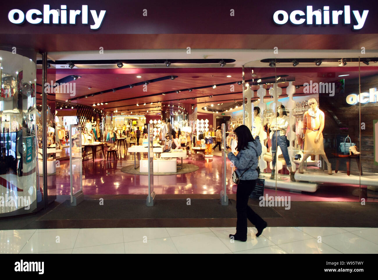 Una passeggiate a piedi passato un Ochirly store in Cina a Shanghai, 13 febbraio 2012. Un privato-equity fund sostenuto dal francese gigante di lusso LVMH Moet Henness Foto Stock