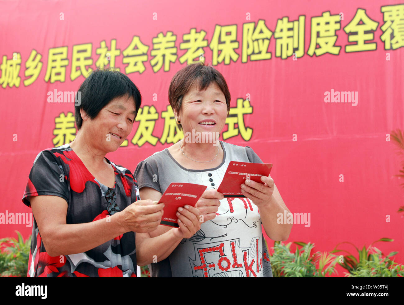 Il sambuco le donne ricevono la loro pensione bankbooks durante una pensione denaro cerimonia di emissione in Tangyin county, porcellane centrale provincia di Henan, 18 luglio 2012. Foto Stock