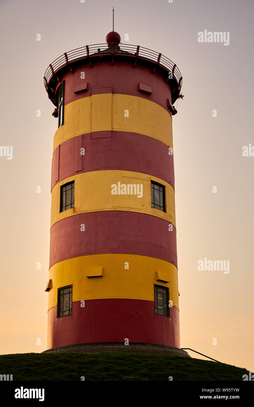 Rosso e giallo faro al tramonto in Pilsum Germania / Bassa Sassonia Foto Stock