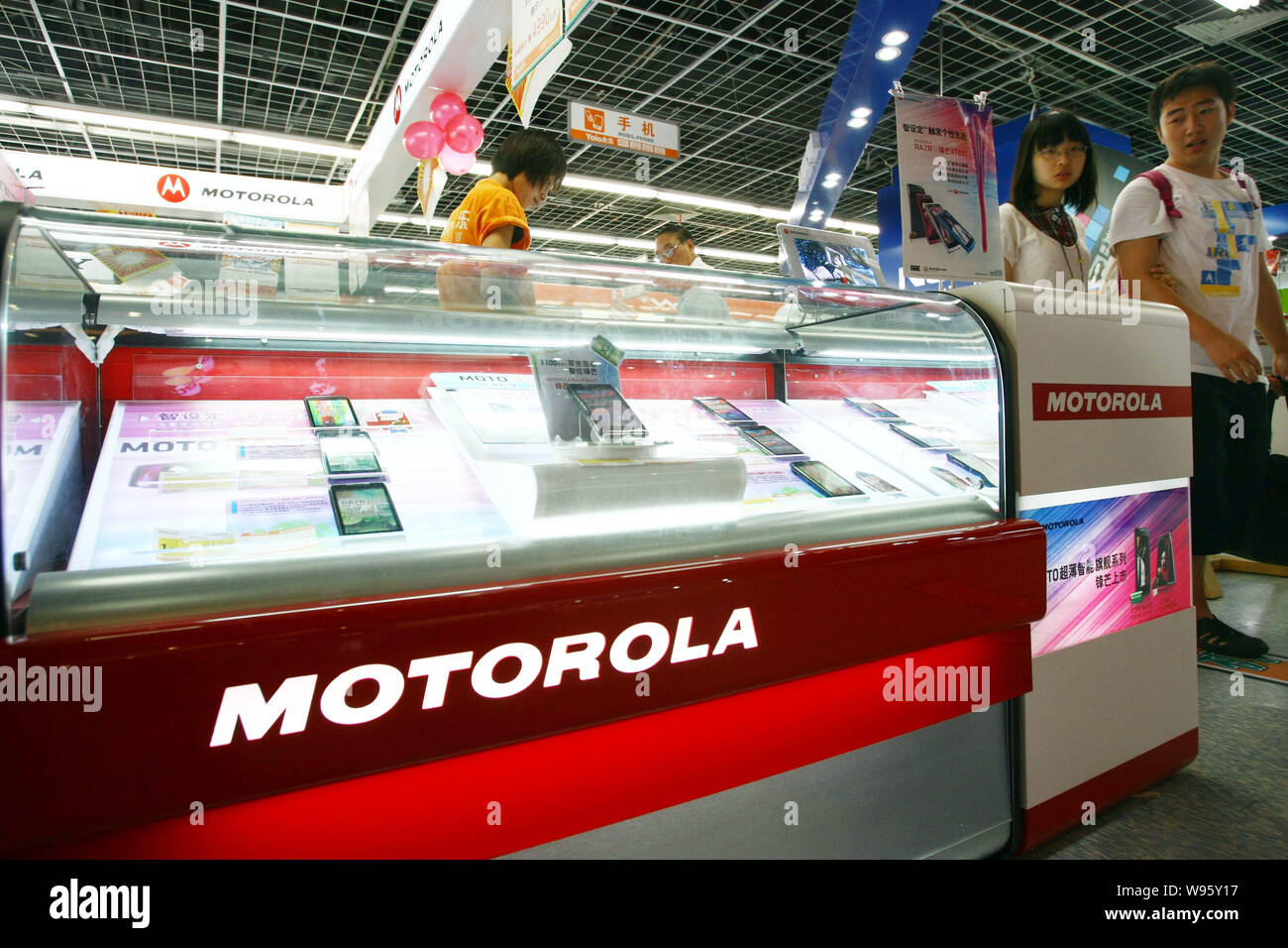 I clienti cinesi a piedi passato il contatore per i cellulari Motorola in un elettrodomestico store in Shanghai, 17 agosto 2012. Stati Uniti Il gigante di Internet Google Foto Stock