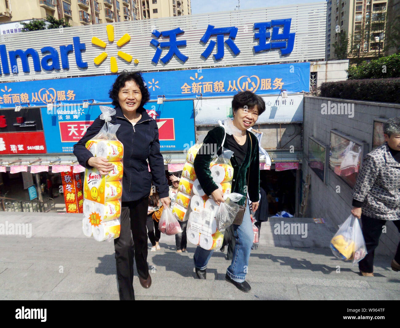 --FILE--i clienti cinesi che trasportano derrate alimentari e prodotti di base a piedi fuori da un supermercato Walmart a Chongqing Cina, 25 ottobre 2011. Wal-Mart Stores In Foto Stock