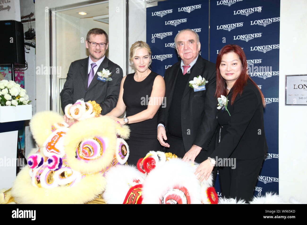 British attrice Kate Winslet, seconda a sinistra, pone dopo una danza leone in occasione della cerimonia di apertura del flagship store di orologio di marca Longi Foto Stock