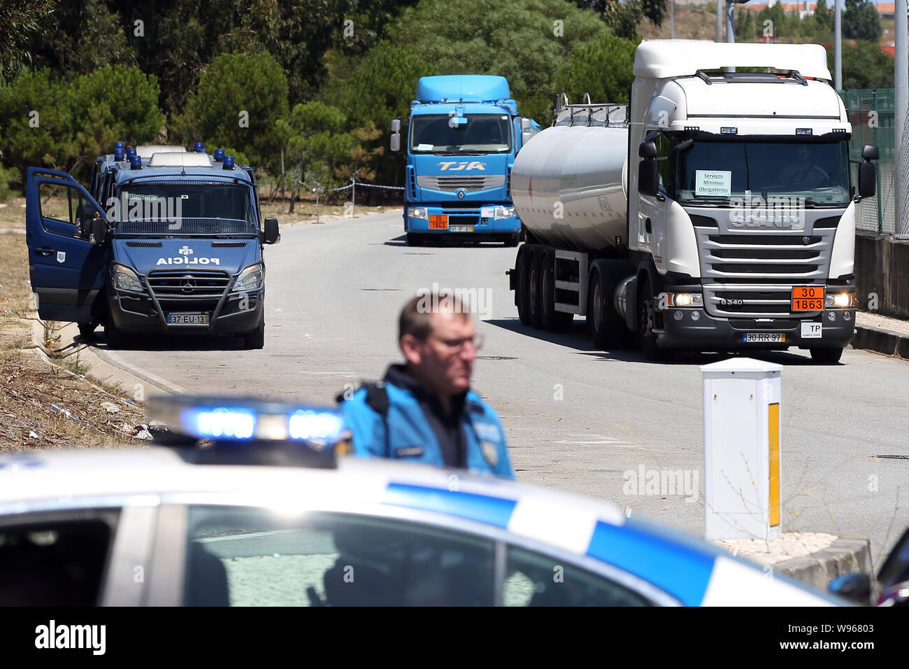 Lisbona, Portogallo. 12 Ago, 2019. Un funzionario di polizia accompagnatrici di combustibile-petroliere lasciando il Humberto Delgado Aeroporto di Lisbona, in Portogallo, il 12 agosto, 2019. Carburante portoghese-cisterna drivers' sciopero nazionale ha cominciato come programmato da lunedì per un periodo indeterminato. In Portogallo il governo ha ordinato i servizi minimi di tra 50% e 100% e ha dichiarato una crisi energetica che implica "misure eccezionali' per ridurre al minimo gli effetti di sciopero per garantire la fornitura di servizi essenziali come le forze di sicurezza e le emergenze mediche. Credito: Pedro Fiuza/Xinhua Foto Stock