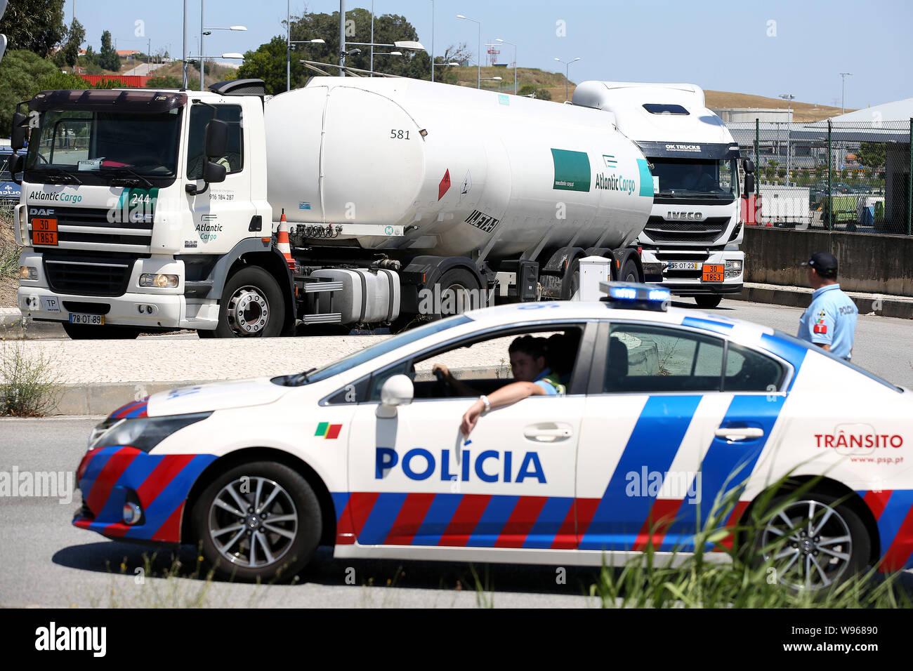 Lisbona, Portogallo. 12 Ago, 2019. I funzionari di polizia del combustibile escort-petroliere lasciando il Humberto Delgado Aeroporto di Lisbona, in Portogallo, il 12 agosto, 2019. Carburante portoghese-cisterna drivers' sciopero nazionale ha cominciato come programmato da lunedì per un periodo indeterminato. In Portogallo il governo ha ordinato i servizi minimi di tra 50% e 100% e ha dichiarato una crisi energetica che implica "misure eccezionali' per ridurre al minimo gli effetti di sciopero per garantire la fornitura di servizi essenziali come le forze di sicurezza e le emergenze mediche. Credito: Pedro Fiuza/Xinhua Foto Stock