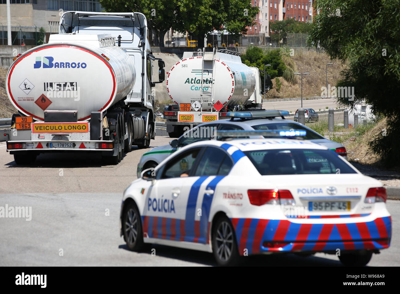 Lisbona, Portogallo. 12 Ago, 2019. Scorta di polizia di combustibile-petroliere lasciando il Humberto Delgado Aeroporto di Lisbona, in Portogallo, il 12 agosto, 2019. Carburante portoghese-cisterna drivers' sciopero nazionale ha cominciato come programmato da lunedì per un periodo indeterminato. In Portogallo il governo ha ordinato i servizi minimi di tra 50% e 100% e ha dichiarato una crisi energetica che implica "misure eccezionali' per ridurre al minimo gli effetti di sciopero per garantire la fornitura di servizi essenziali come le forze di sicurezza e le emergenze mediche. Credito: Pedro Fiuza/Xinhua Foto Stock