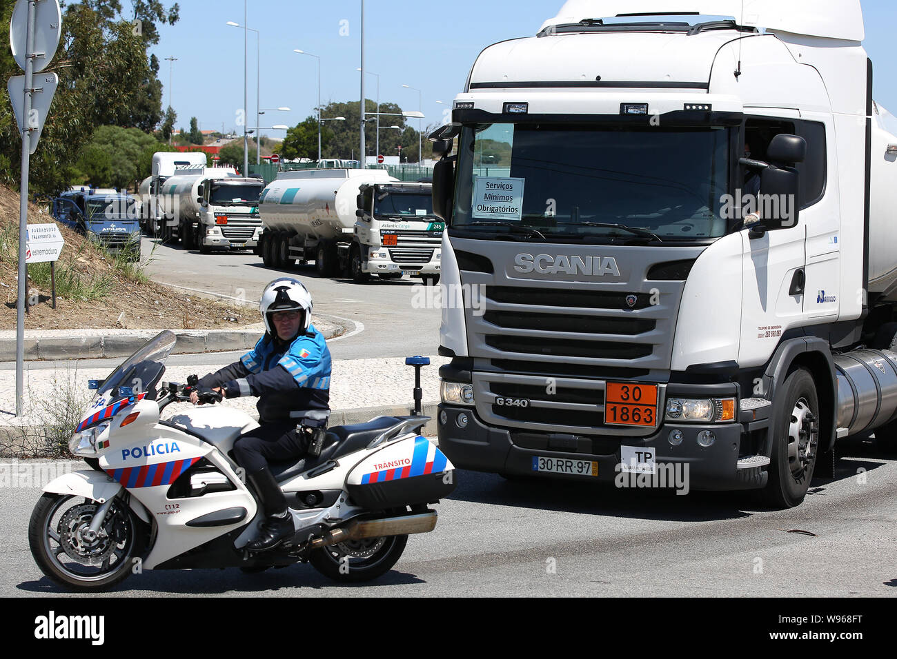 Lisbona, Portogallo. 12 Ago, 2019. Un funzionario di polizia accompagnatrici di combustibile-petroliere lasciando il Humberto Delgado Aeroporto di Lisbona, in Portogallo, il 12 agosto, 2019. Carburante portoghese-cisterna drivers' sciopero nazionale ha cominciato come programmato da lunedì per un periodo indeterminato. In Portogallo il governo ha ordinato i servizi minimi di tra 50% e 100% e ha dichiarato una crisi energetica che implica "misure eccezionali' per ridurre al minimo gli effetti di sciopero per garantire la fornitura di servizi essenziali come le forze di sicurezza e le emergenze mediche. Credito: Pedro Fiuza/Xinhua Foto Stock