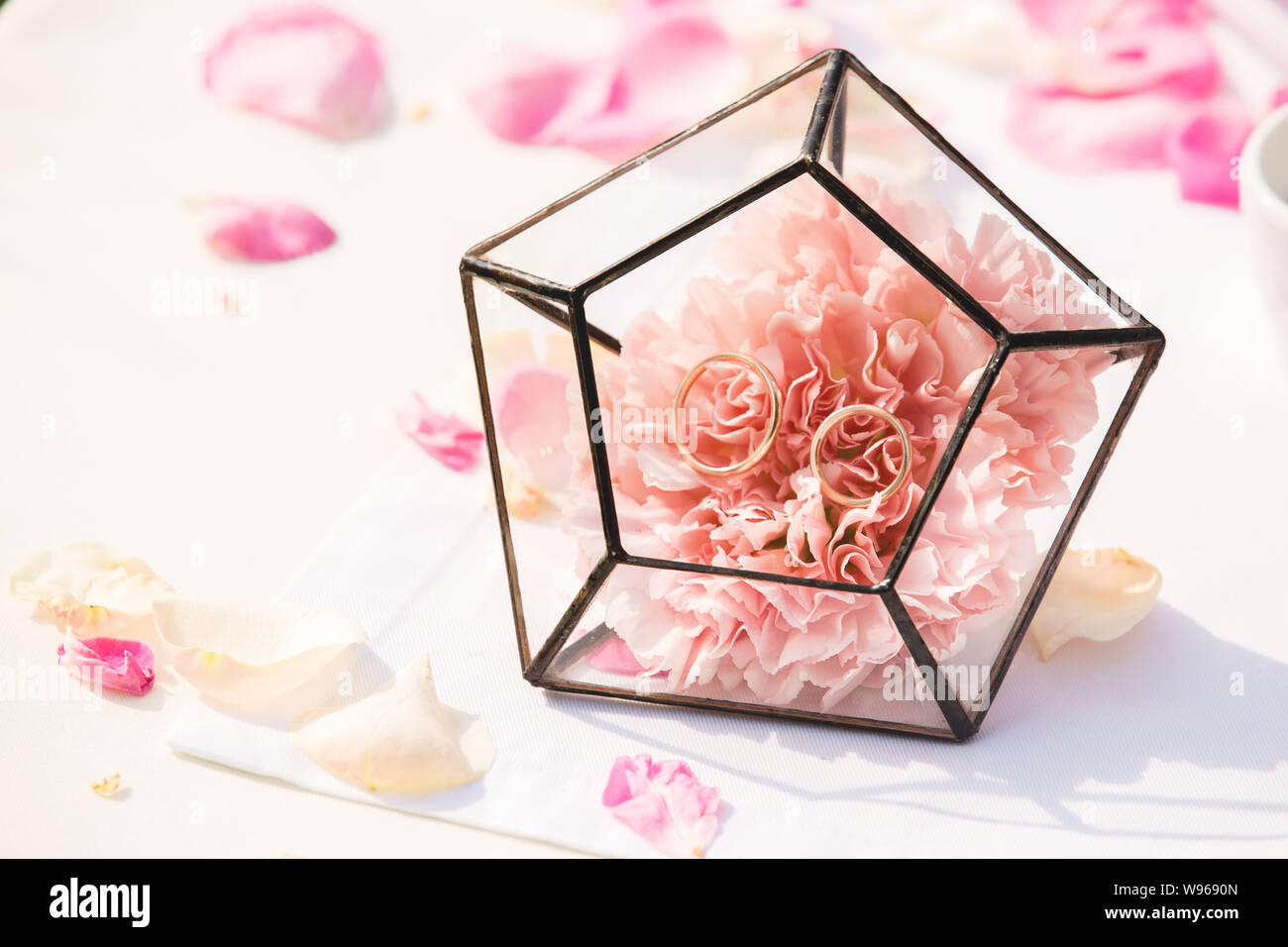 Close-up foto di bellissimi anelli di nozze dettagli su rosa rosa fiore Foto Stock