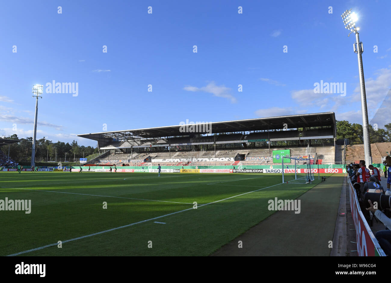 12 agosto 2019, Baden-Wuerttemberg, Karlsruhe: Calcio: DFB Cup, Karlsruher SC - Hannover 96, 1° round in Wildparkstadion. Vista della tribuna opposta, che attualmente viene demolito a causa della costruzione di un nuovo stadio. (Nota importante: la DFB vieta l' uso di immagini in una sequenza su Internet e nei contenuti multimediali in linea durante il gioco (compresa la metà tempo). Periodo di bloccaggio! La DFB permette la pubblicazione e un ulteriore utilizzo di immagini su dispositivi mobili (soprattutto MMS) e via DVB-H e DMB solo dopo la fine del gioco.) Foto: Uli Deck/dpa - NOTA IMPORTANTE: In conformità con il re Foto Stock