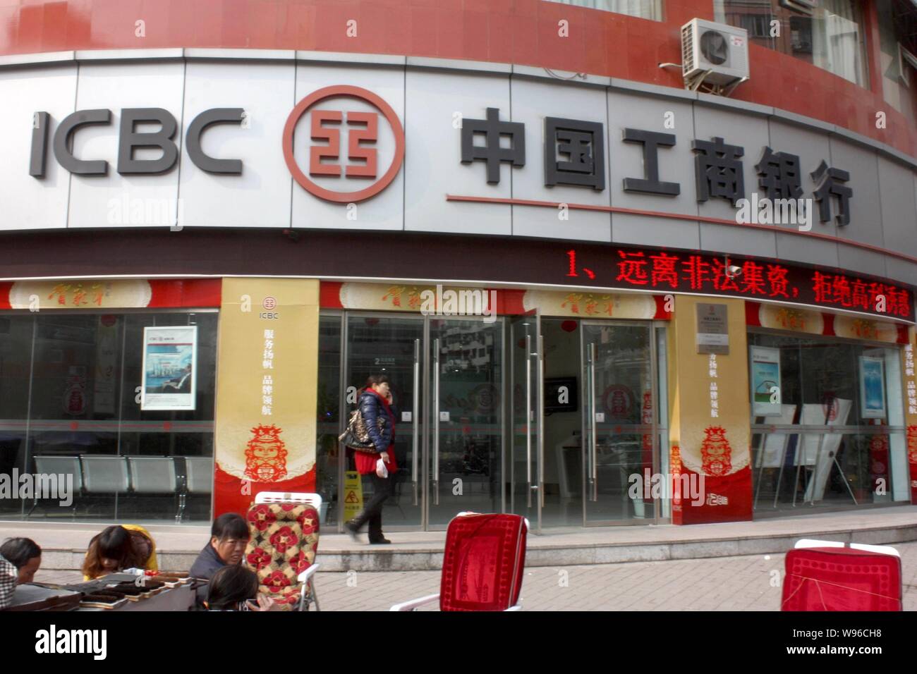 --File--una donna cammina davanti a un ramo di industriali e di banca commerciale della Cina (ICBC) a Chongqing Cina, 12 gennaio 2012. Gli Stati Uniti il mer Foto Stock