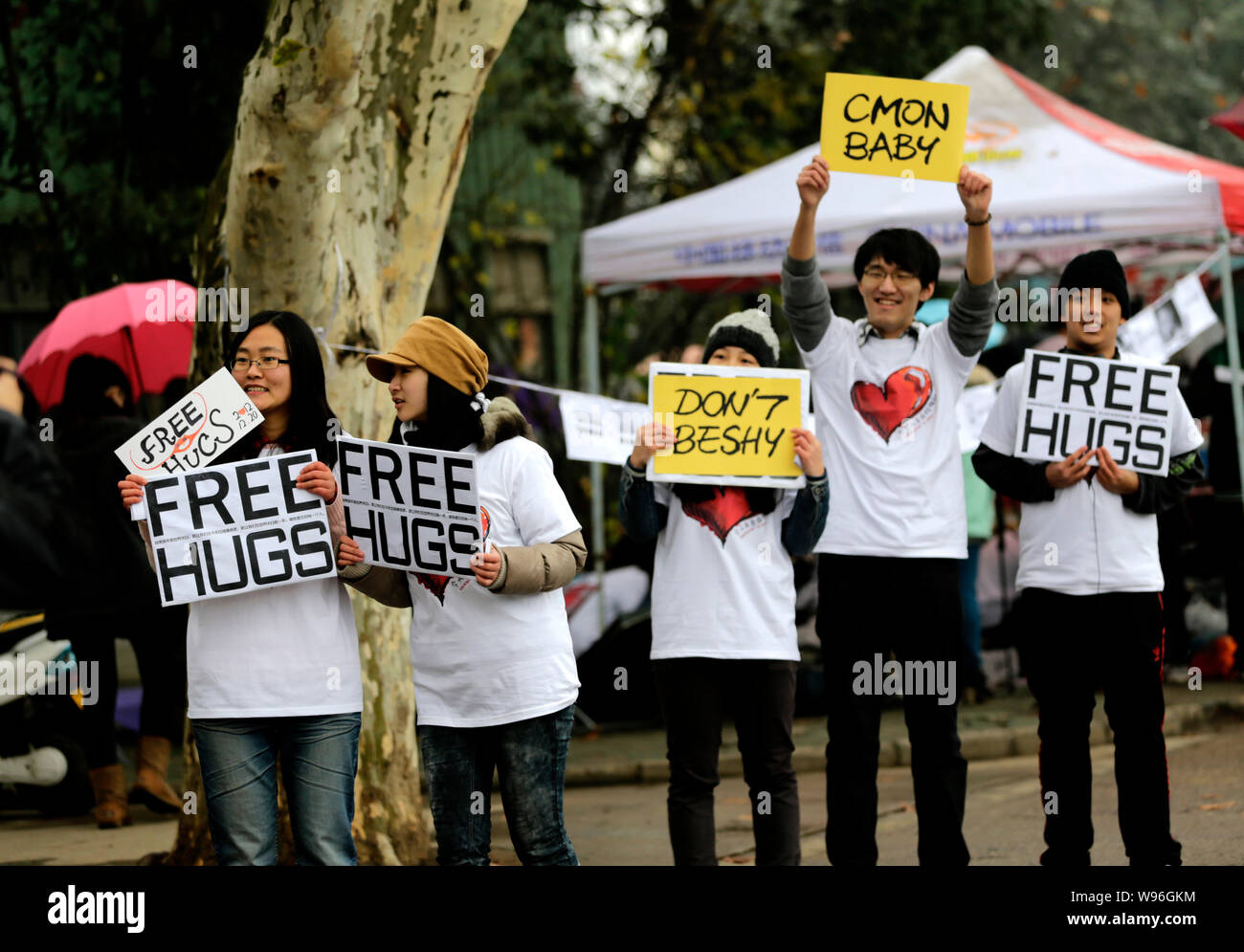 Giovani studenti cinesi tenere indicazioni dicendo, Free Hugs, durante una campagna per contrassegnare la fine del mondo dall'apocalisse Maya a Wuhan University in W Foto Stock