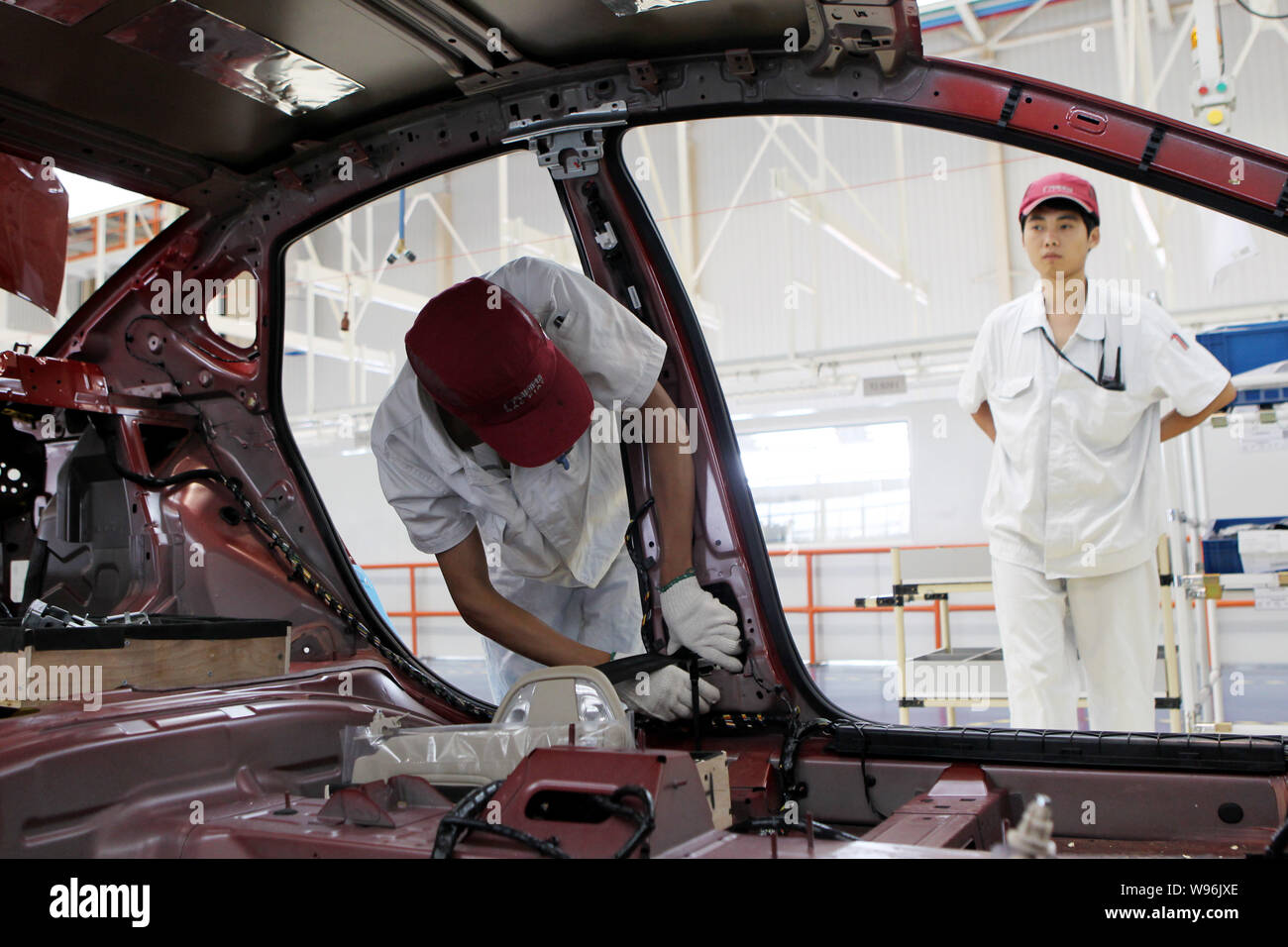 Un lavoratore cinese assembla un viaggio di Fiat auto sulla linea di montaggio a GAC Fiat WCM stabilimento di Changsha city, porcellane centrale nella provincia del Hunan, 28 giugno Foto Stock