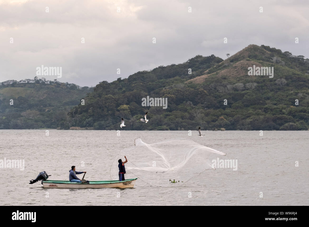 I pescatori usano un cast net presso il lago in Catemaco Catemaco, Veracruz, Messico. La tropicale lago di acqua dolce al centro della Sierra de Los Tuxtlas, è una destinazione turistica popolare e conosciuto per libera compresa scimmie, la foresta pluviale sfondo e streghe messicano noto come Brujos. Foto Stock