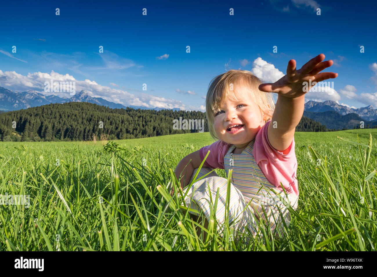 In Germania, in Baviera, Allgaeu, Happy Baby girl giocando nei campi Foto Stock