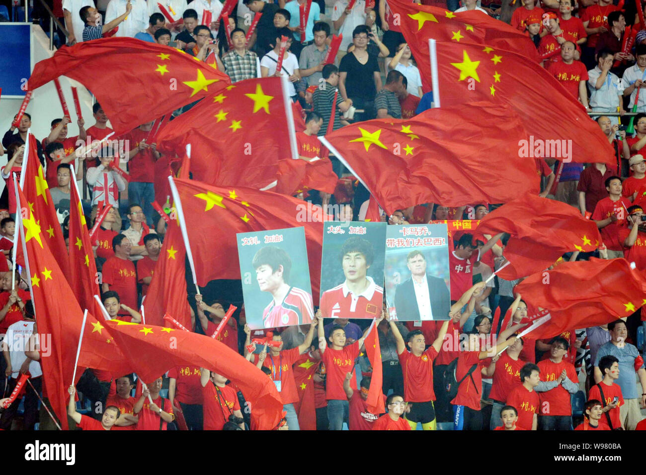 I fan cinesi tifare per mostrare il supporto per il cinese uomini nazionali di calcio in un 2014 FIFA World Cup qualifier match tra Cina e Iraq in Shenzhe Foto Stock