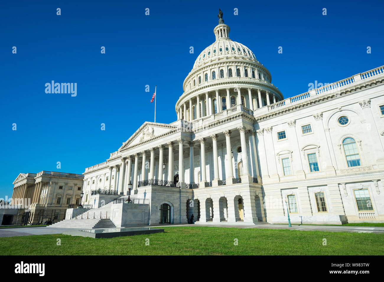 United States Capitol Building Washington DC USA vista panoramica con estate erba verde che circonda la scalinata d'ingresso sotto il cielo blu chiaro Foto Stock