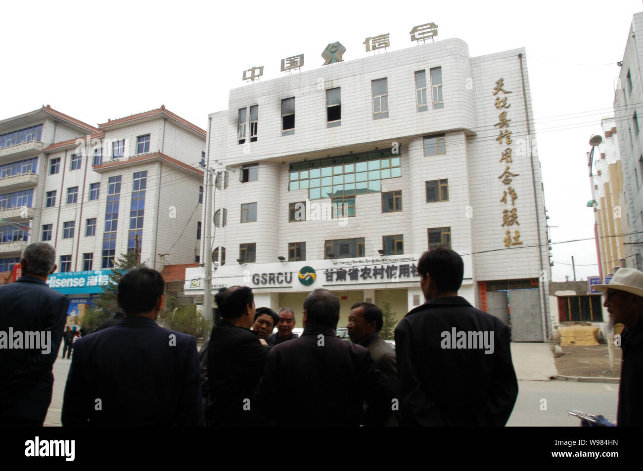 La gente del posto a piedi passato l'agricoltura Cooperativa di credito dopo un attentato alla sua quinto piano in Tianzhu county, a nord-ovest Chinas provincia di Gansu, 13 maggio Foto Stock