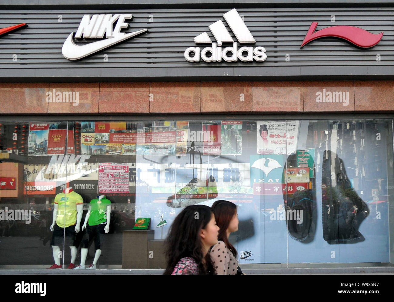 FILE--i residenti locali a piedi passato signages di Nike, Adidas e Li-Ning  presso un negozio di abbigliamento sportivo a Yichang city, porcellane  centrale provincia di Hubei, 23 aprile Foto stock - Alamy