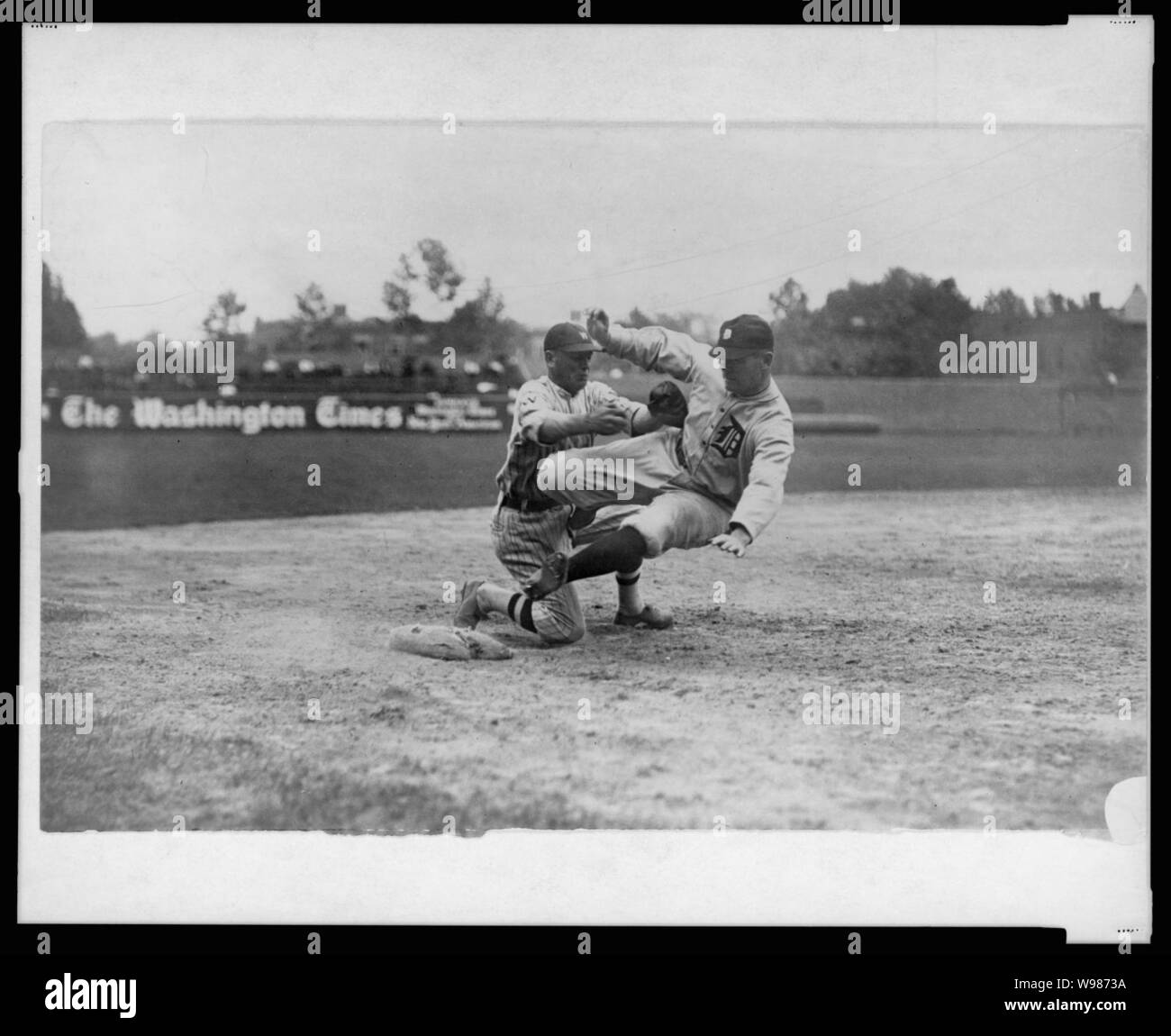 Detroit Tigers" Harry Heilmann, in un mal eseguito, slitta è contrassegnato da Washington senatori' terzo baseman Howard gambi. Senatori battere le tigri 6-2 Foto Stock
