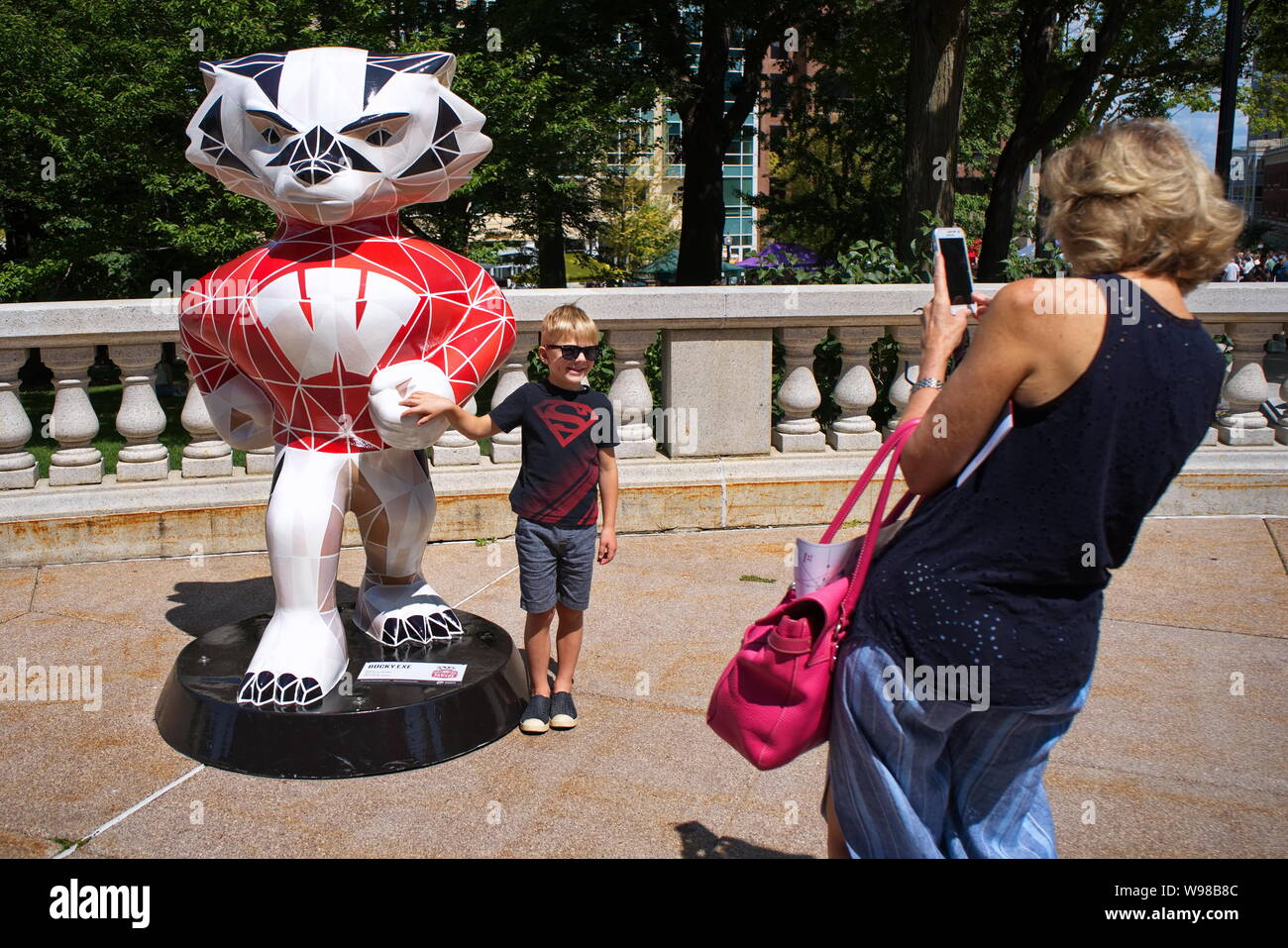 Wisconsin State Capitol, Madison, WI, Stati Uniti d'America. Aug 2018. Kid accanto a Bucky Badger posa per la nonna. Foto Stock