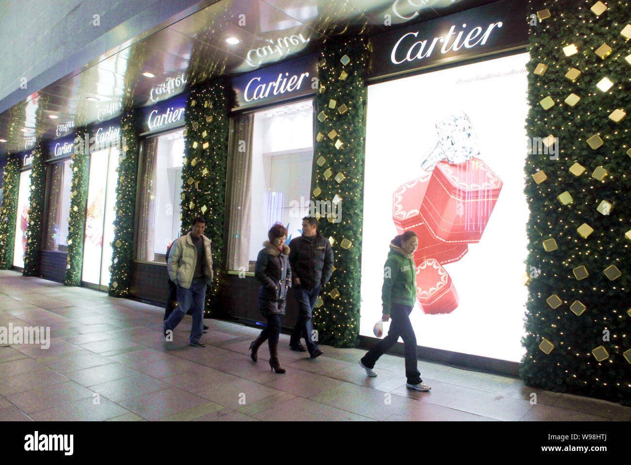 --FILE--Cinesi locali residenti a piedi passato una boutique Cartier a Shanghai in Cina, 13 dicembre 2010. Cartier, il creatore di gioielli in cui i clienti hanno inc Foto Stock