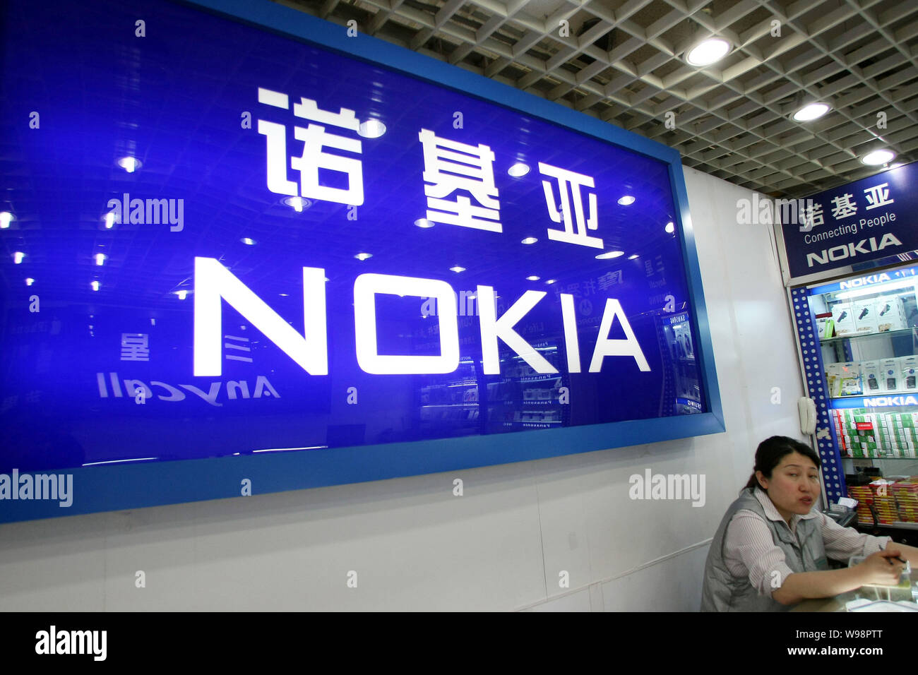 --FILE -- un venditore si siede accanto al logo di Nokia in un negozio a Shanghai in Cina, 15 aprile 2011. Nokias margine di profitto maggiore uccidendo mal di testa ap Foto Stock
