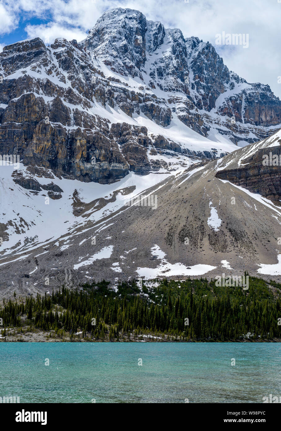 Montagna Crowfoot - verticale - una molla vista della coperta di neve montagna Crowfoot imponente sulla riva del lago di prua, il Parco Nazionale di Banff, Alberta, Canada. Foto Stock