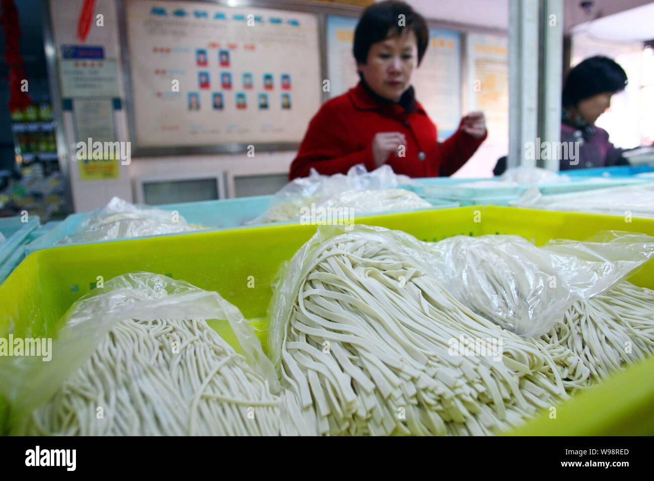 Locali residenti cinesi acquistare tagliatelle in un libero mercato in Cina a Shanghai, 24 febbraio 2011. Le autorità cinesi hanno vietato la produzione di due foo Foto Stock