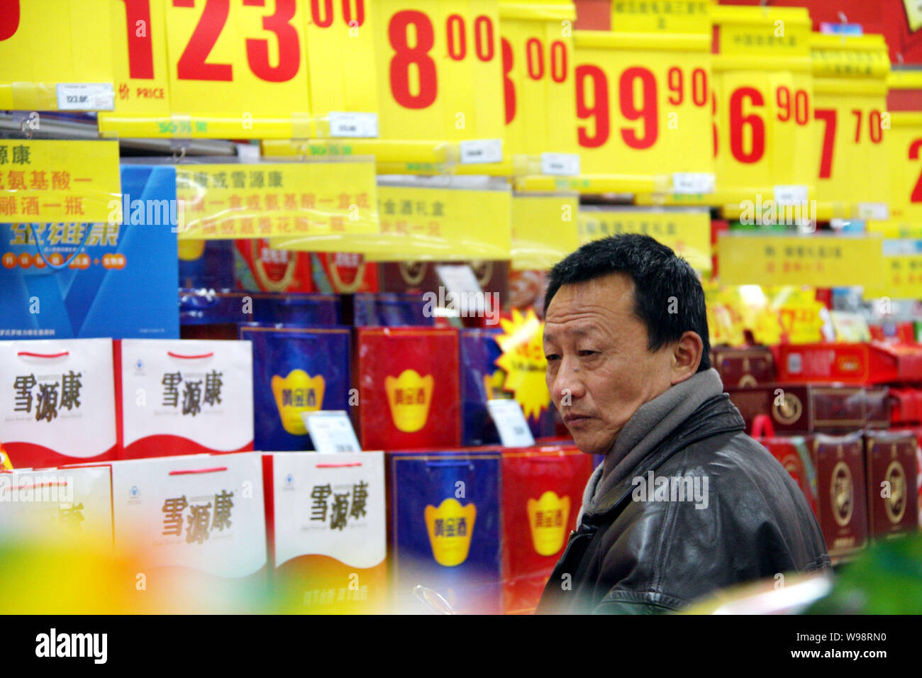 --FILE--un acquirente cinese riguarda i prezzi mentre gli acquisti in un supermercato in città di Nantong, est Chinas provincia dello Jiangsu, 24 gennaio 2011. Pr cinese Foto Stock