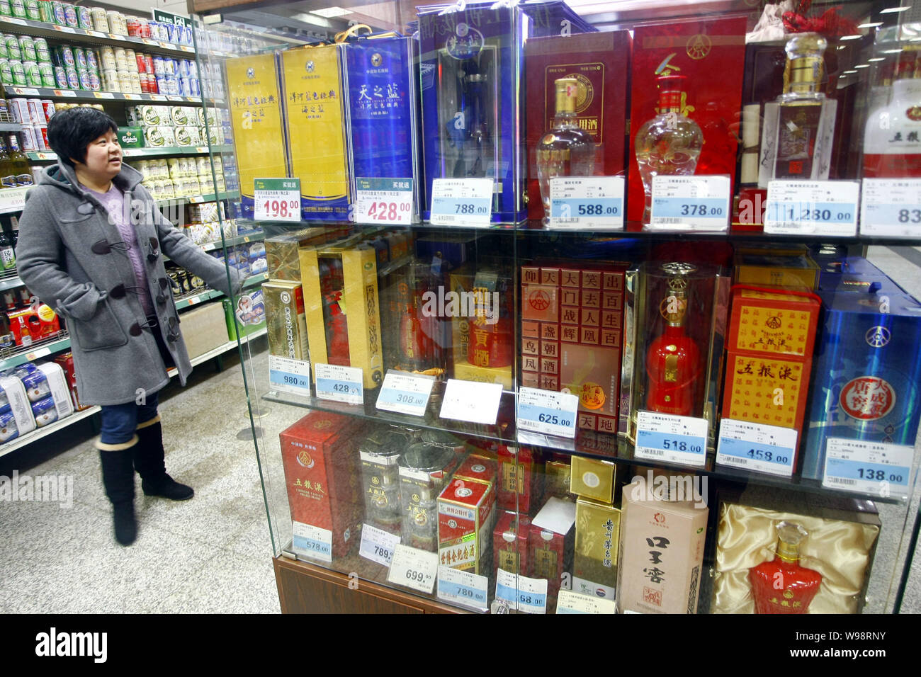 --FILE--un cliente cinese per negozi di liquori in un supermercato a Shanghai in Cina, 4 gennaio 2011. Più di 4 miliardi di litri di bianco lo spirito erano Foto Stock