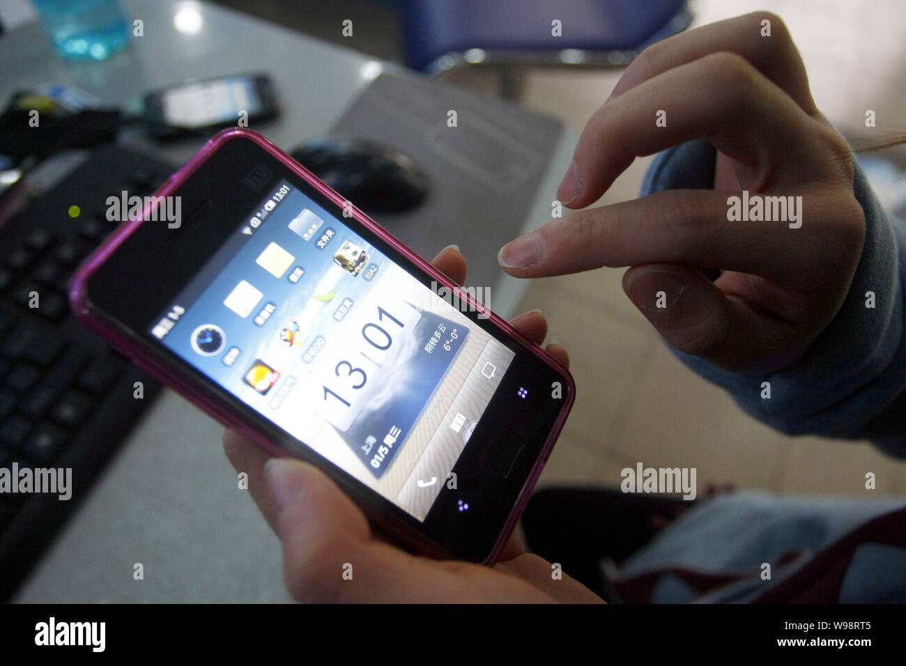 Un cliente cinese tenta di eseguire il Meizu M9 smartphone a un Meizu mobile phone store in Cina a Shanghai, 5 gennaio 2011. La Cina Telecom Industria come Foto Stock