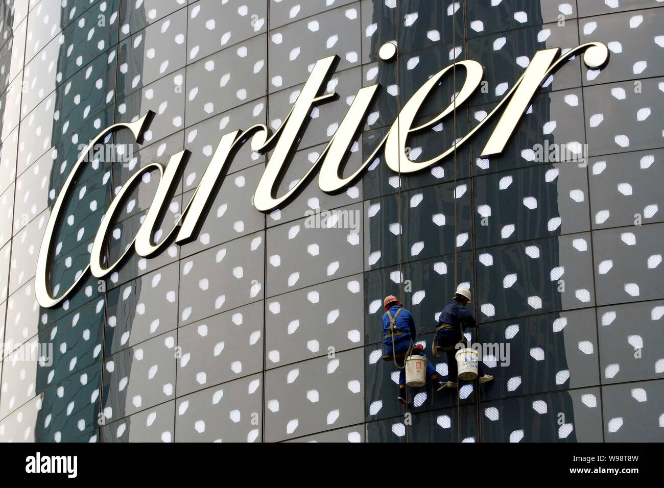 --FILE--lavoratori cinesi la polvere dalla facciata della boutique Cartier a Hong Kong Plaza in Cina a Shanghai, il 9 ottobre 2010. Cartier, la gioielleria Foto Stock