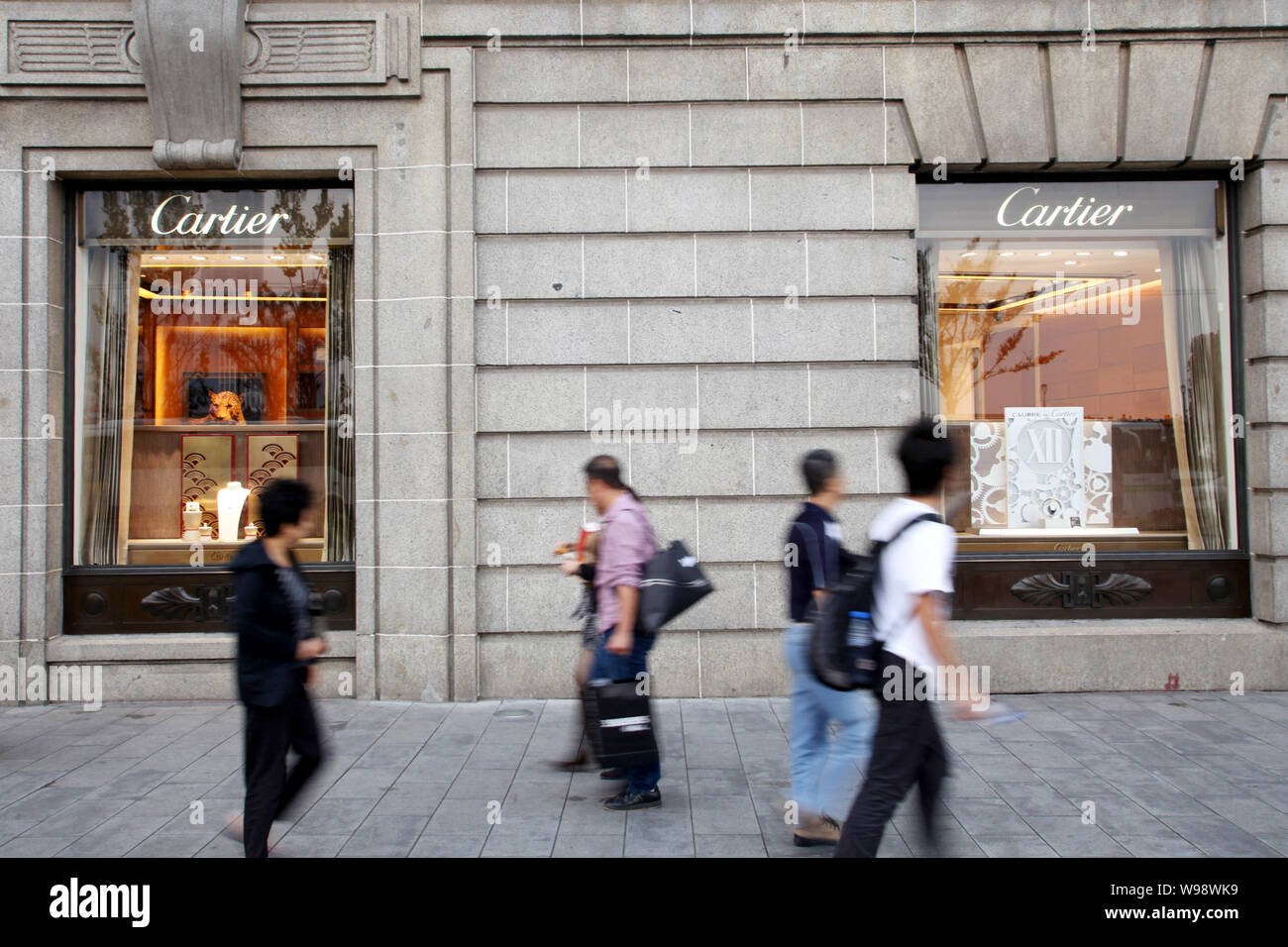 --FILE--turisti e residenti locali a piedi passato la boutique Cartier vicino al Bund in Cina a Shanghai, 15 ottobre 2010. Cartier, il creatore di gioielli wh Foto Stock