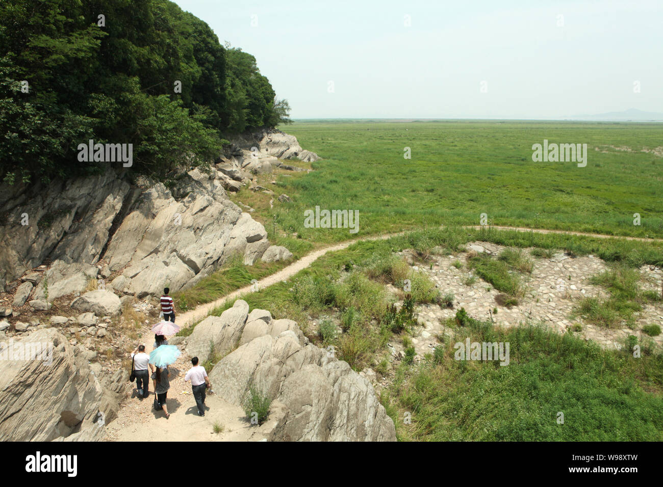 La gente a piedi attraverso una prateria dove usato per essere acqua area del Lago Dongting durante una siccità che ha colpito la città di Yueyang, porcellane centrale nella provincia del Hunan, 29 maggio 20 Foto Stock