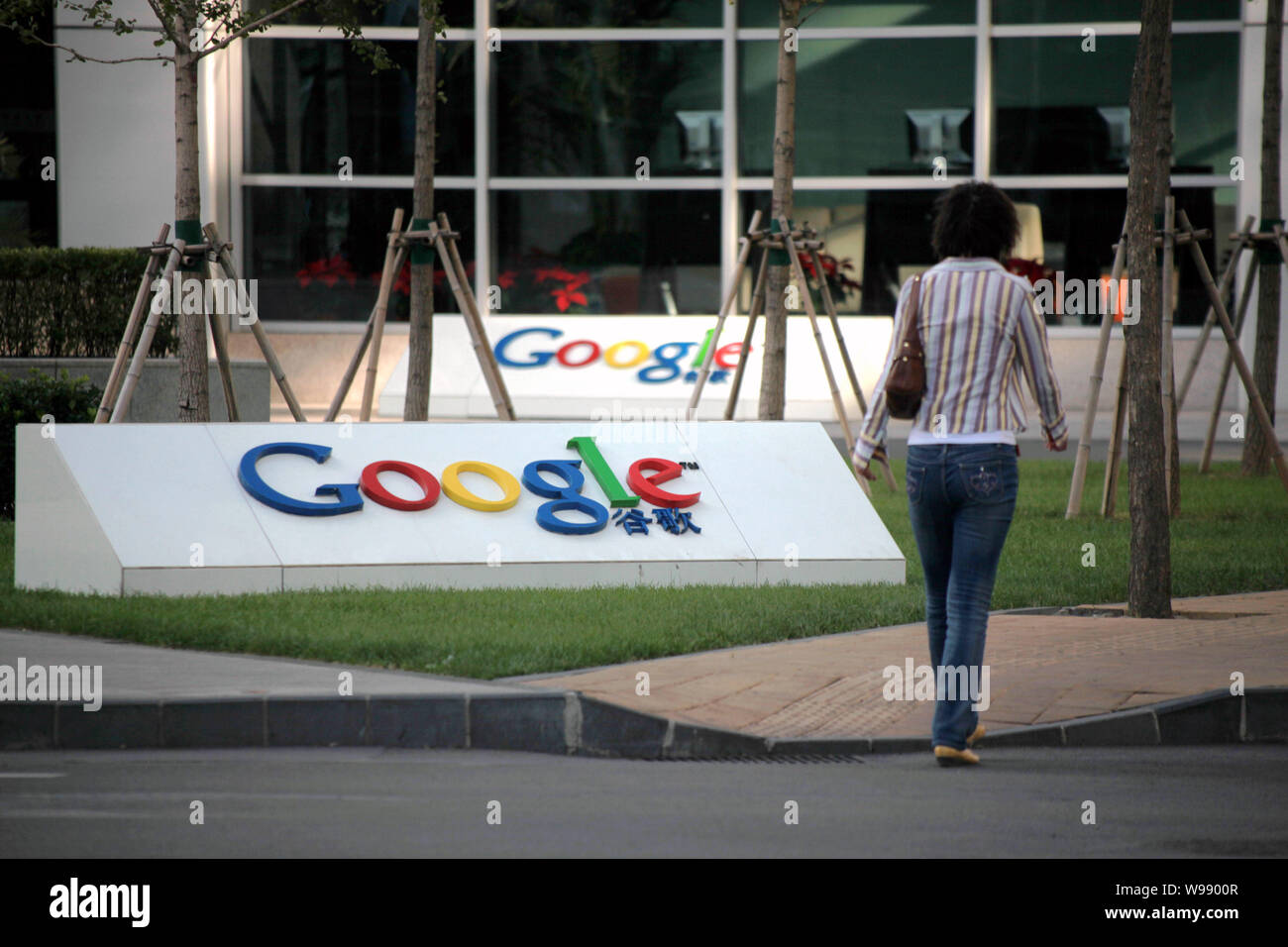 --File-- Una donna cinese passeggiate passato il logo di Google al di fuori della sede di Google in Cina a Pechino in Cina, 3 ottobre 2009. Google è ricaricare Foto Stock