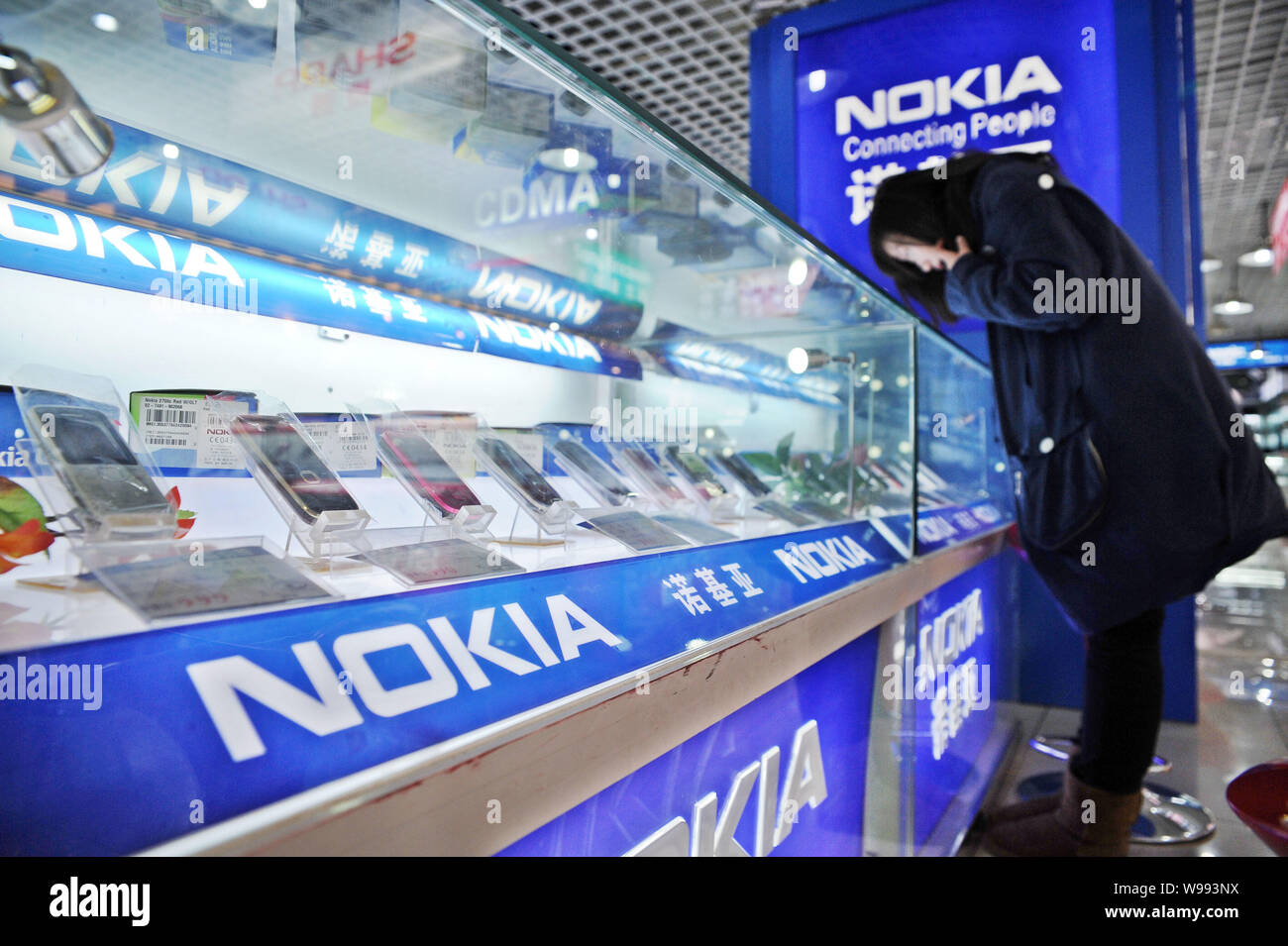 --FILE--una shopper guarda i telefoni cellulari Nokia in un negozio a Shanghai in Cina, 3 marzo 2011. Nokias margine di profitto maggiore uccidendo mal di testa sembrano Foto Stock